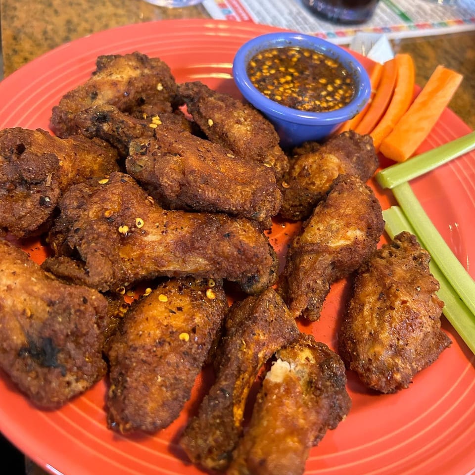 Frida's Mexican Restaurant & Cantina's crispy chicken wings with spicy dipping sauce, carrots, and celery.